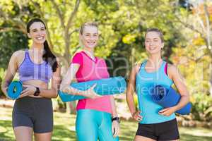 Portrait of young women holding exercise-mat