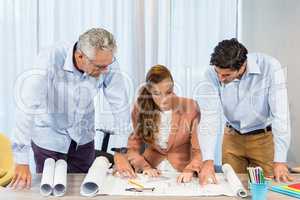 Businesswoman and coworkers discussing blueprint