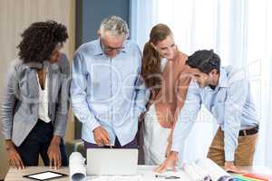 Businesswoman and coworker discussing blueprint on the desk