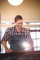 Smiling waiter serving a cup of coffee