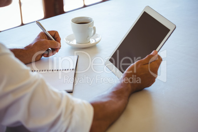 Man using tablet and notebook