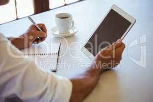 Man using tablet and notebook