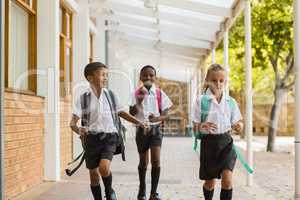 Smiling school kids running in corridor