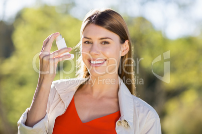 Portrait of beautiful woman using asthma inhaler