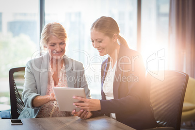 Businesswomen interacting using digital tablet