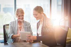 Businesswomen interacting using digital tablet