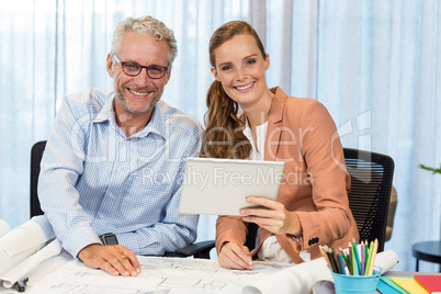 Businesswoman and coworker interacting using digital tablet