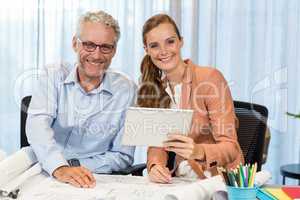 Businesswoman and coworker interacting using digital tablet