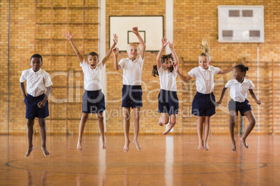 Group of students jumping in school gym