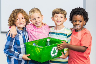 Kids holding recycled bottle in box