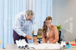 Businesswoman and coworker discussing blueprint
