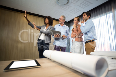 Woman framing with hand while standing in board room with collea