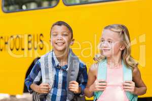 Kids standing in front of school bus