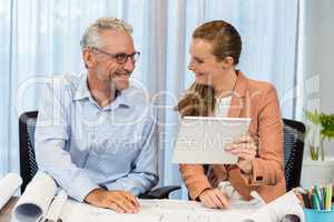 Businesswoman and coworker interacting using digital tablet