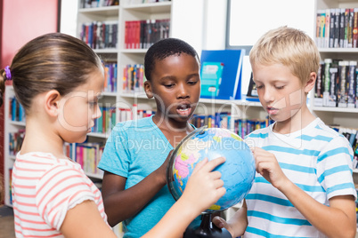 Kids studying globe in library