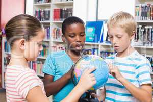 Kids studying globe in library