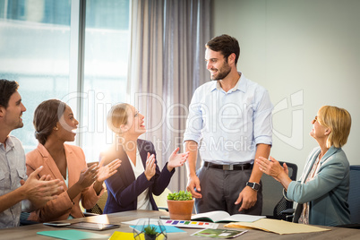 Coworkers applauding a colleague after presentation