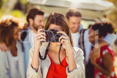 Woman clicking a photo from camera in park