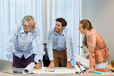 Businesswoman and coworker discussing blueprint