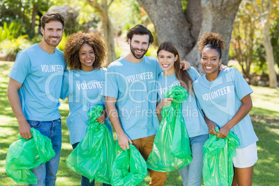 Portrait of volunteer group posing while collecting rubbish