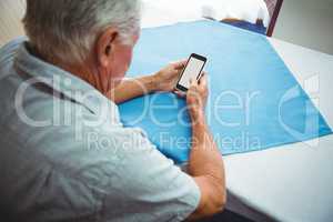 seated retired man looking at his smartphone