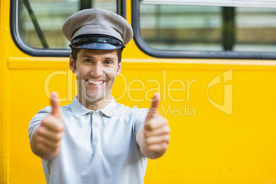 Smiling bus driver showing thumbs up in front of bus