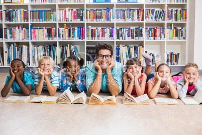 Teacher and kids lying on floor in library