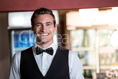Portrait of bartender standing at bar