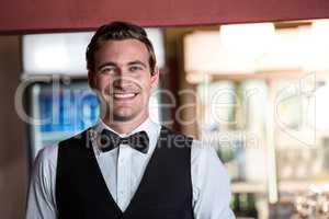 Portrait of bartender standing at bar