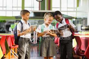 School kids using digital tablet in school cafeteria