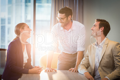 Businessmen and businesswoman interacting at their desk