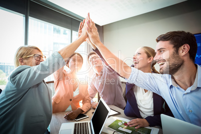 Business people giving high five at desk