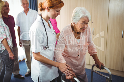 Nurse helping a retired woman to walk