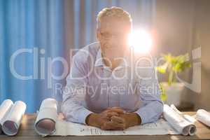 Man sitting with blueprint at his desk