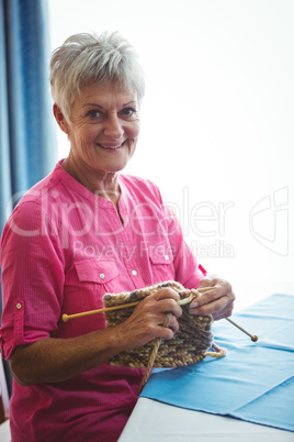 Retired smiling woman doing some knitting