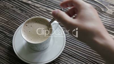 A cup of cappuccino with foam is on the table