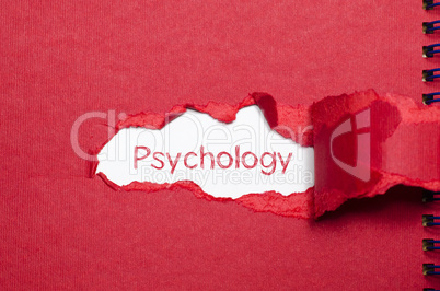 The word psychology appearing behind torn paper.