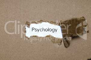 The word psychology appearing behind torn paper.