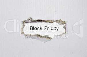 The word black friday appearing behind torn paper