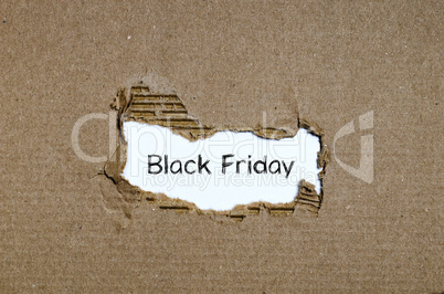 The word black friday appearing behind torn paper