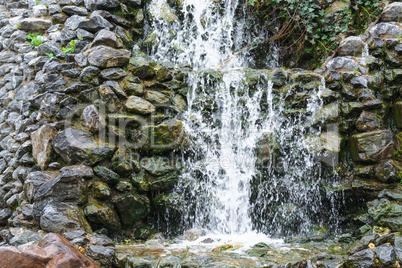 Kleiner Wasserfall, Kaskaden fließt über moosige Felsesteine