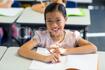 Smiling girl writing on book