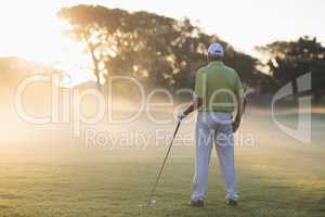 Rear view of mature golf player