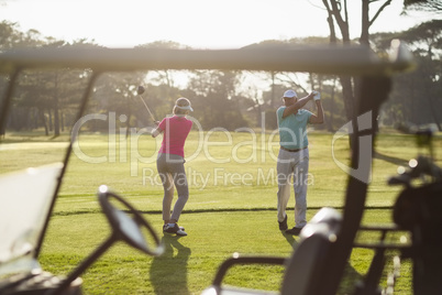 Full length of mature couple playing golf