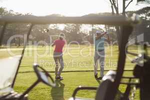 Full length of mature couple playing golf