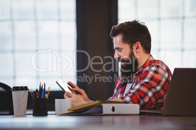 Hipster using tablet computer at desk