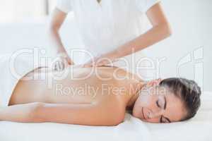 Relaxed naked woman receiving massage