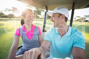 Smiling golfer couple looking at each other