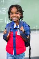 Smiling boy standing against board in classroom