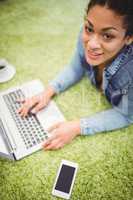 High angle portrait of businesswoman using laptop on carpet